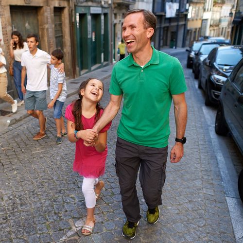 a father and daughter walking hand in hand