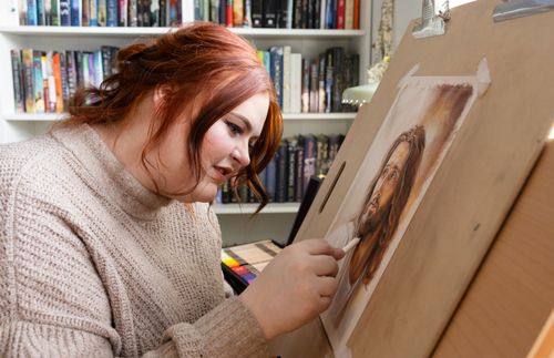 woman working on a painting of the Savior