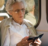 A Brazilian woman reading the scriptures.  She is sitting on a bus.