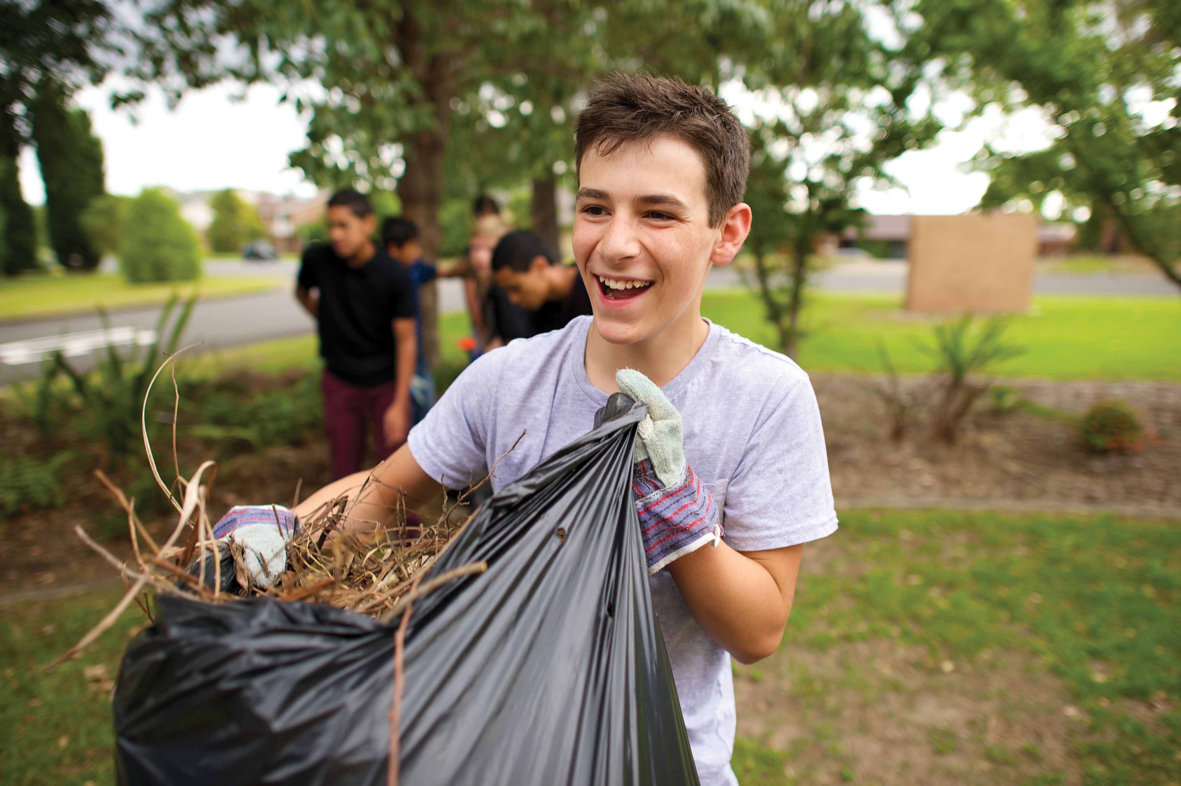 A group of young men clean up a yard.
