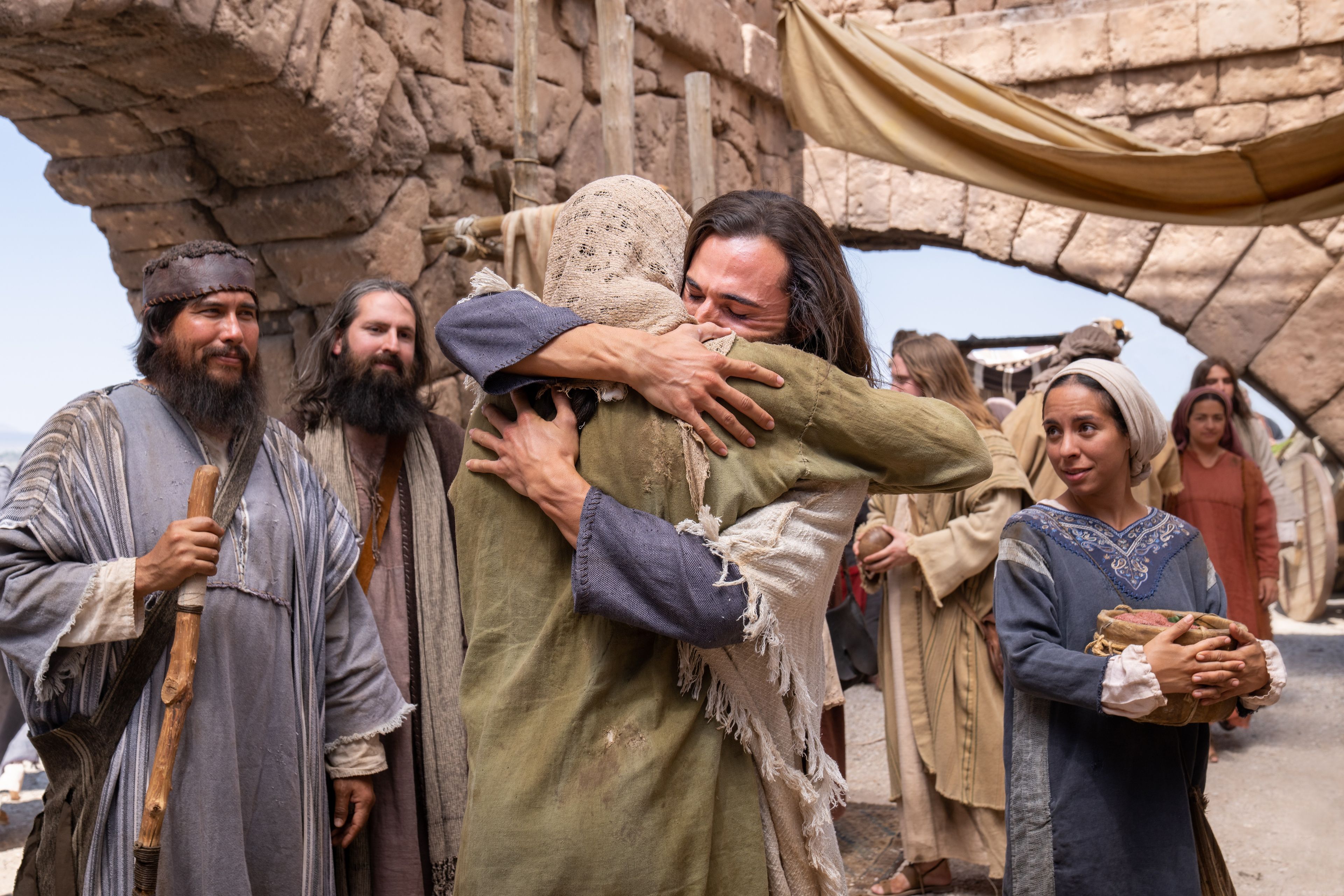 Jesus Christ greets Peter in an embrace. Near them are John and James.