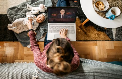 young mom watching general conference while caring for a baby