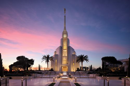 The exterior of the Rome Italy Temple at night at sunset.