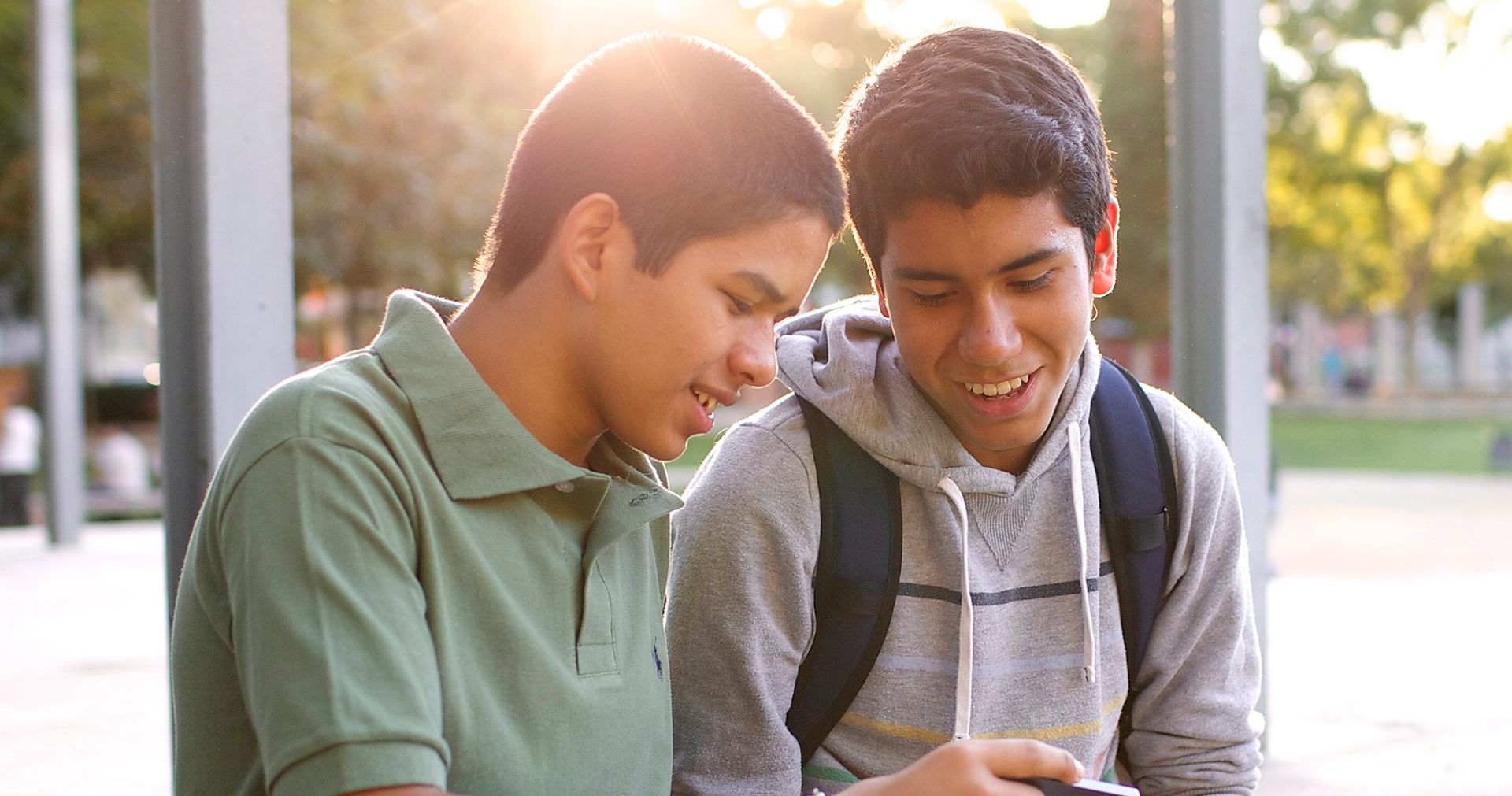 Two young men looking at a cell phone.