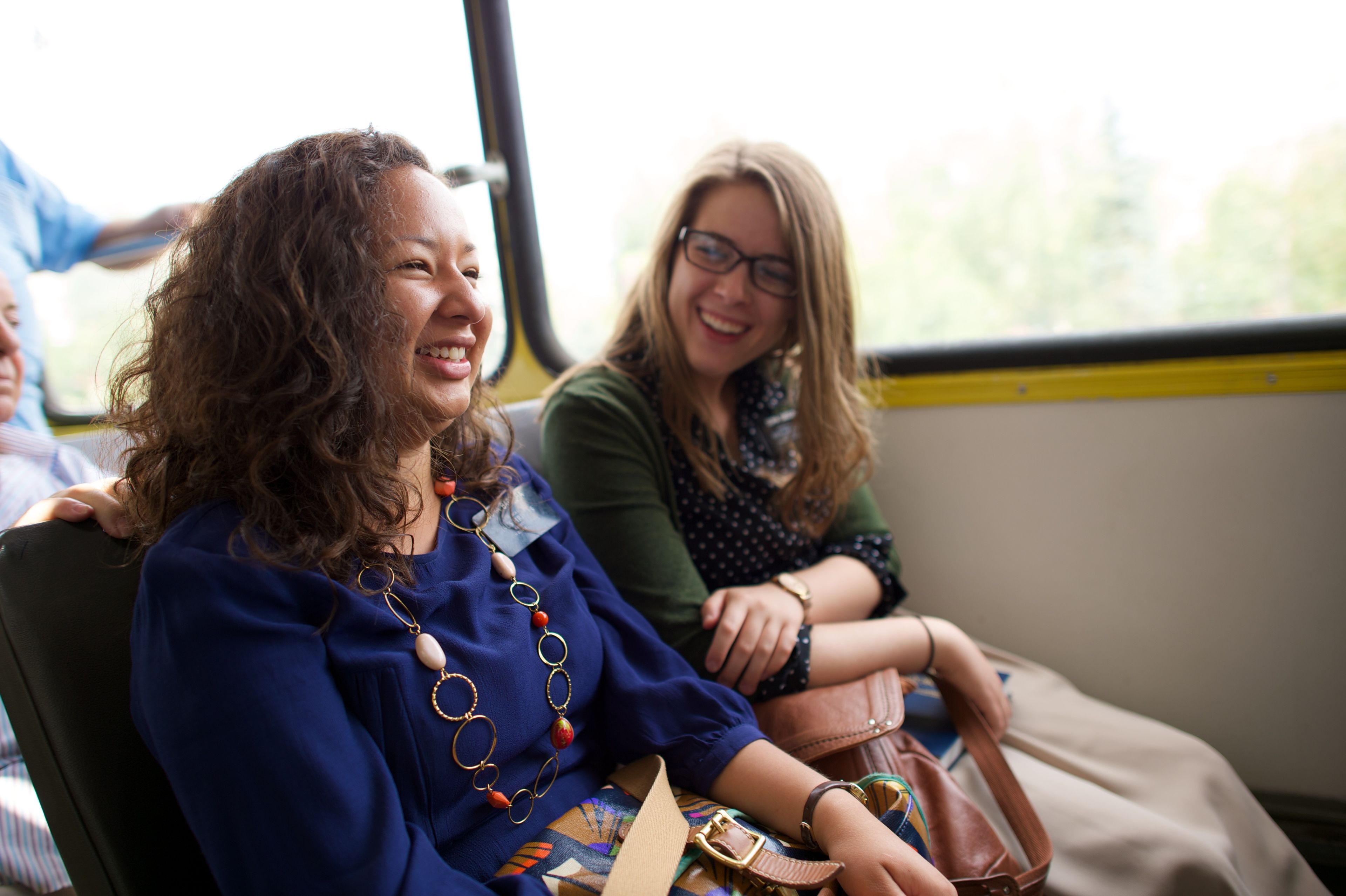 Two sister missionaries in Romania laugh while sitting beside each other.