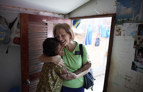 senior missionary hugging Cambodian woman