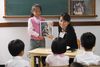 child holding picture, and teacher pointing at it