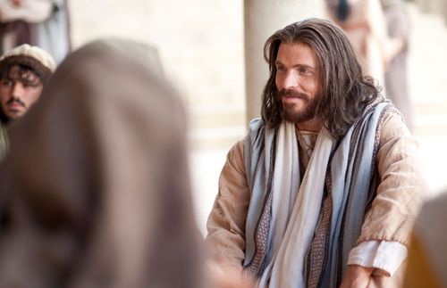 Jesus Christ sitting on the ground and teaching a group of people