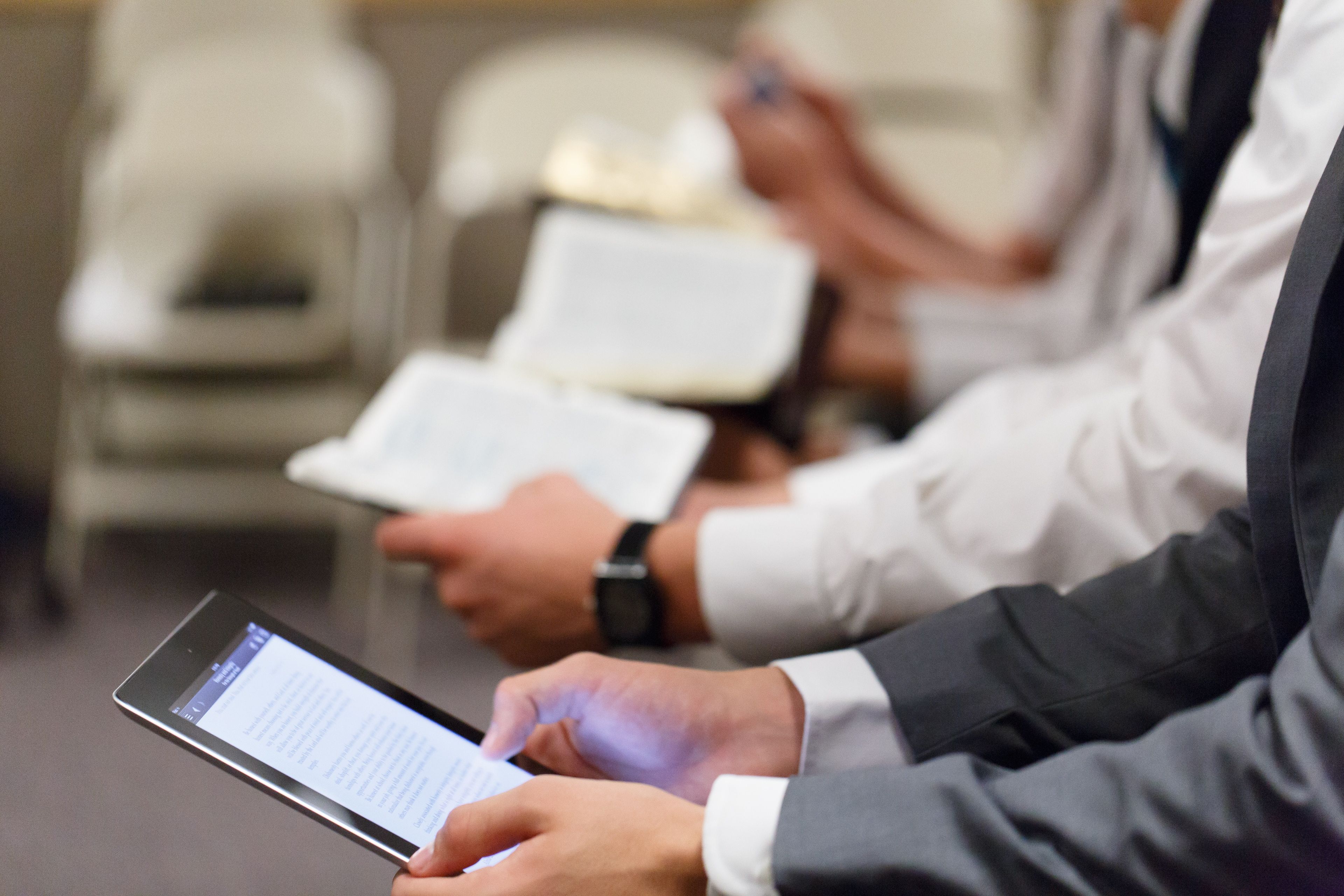 A man reads his scriptures from a tablet.