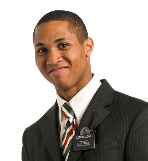 Portrait of a happy, smiling, black missionary in his suit and tie and missionary name tag.