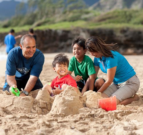 una familia construyendo un castillo de arena