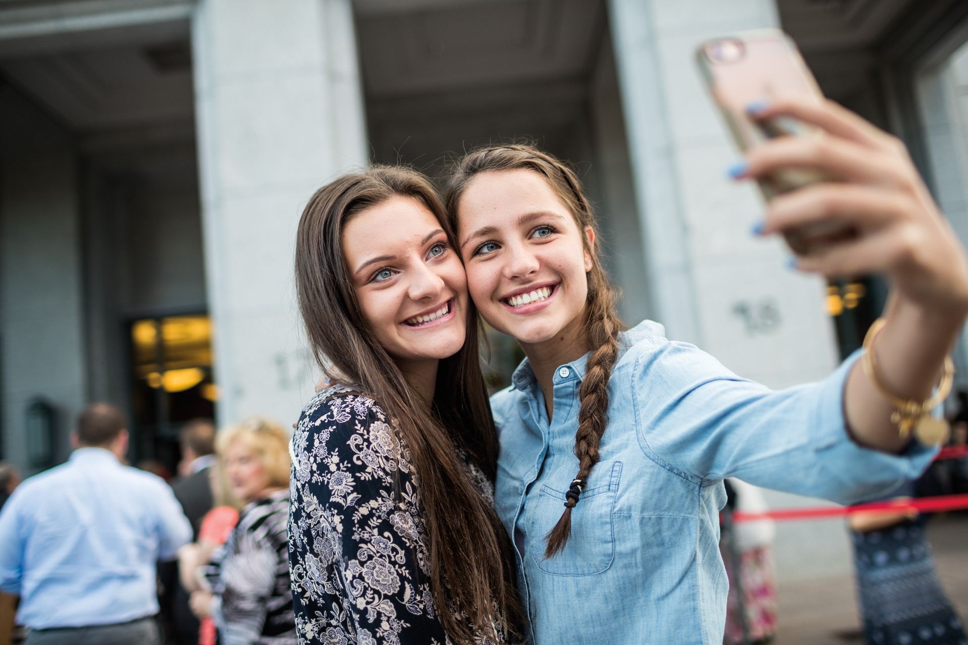 Two teenage girls take a selfie outside of the Conference Center while attending general conference.