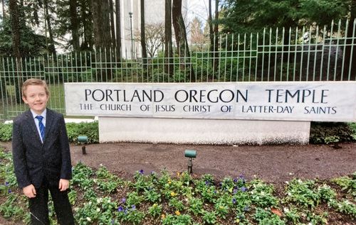 Boy standing by temple sign