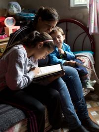 mother studying scriptures with children