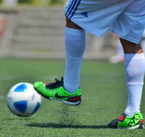 menino chutando uma bola de futebol