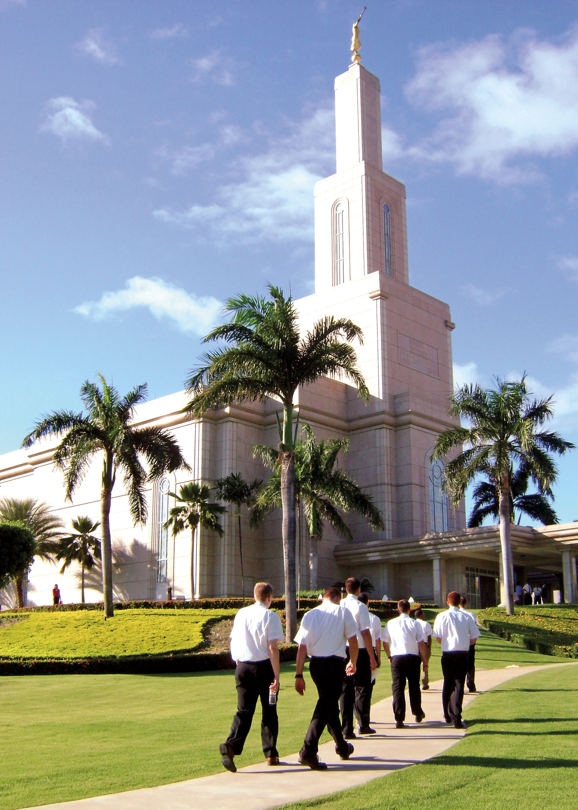 A group of elder missionaries walking toward a temple.