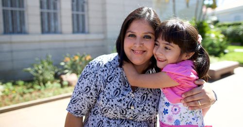 Mother and daughter hug on Asuncion Paraguay Temple grounds.