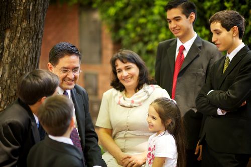 A mother and father sit outside the chapel after church on Sunday with their four sons and daughter.