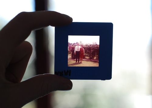 A shot of someone holding up a film slide. On the slide you can see a husband and wife.