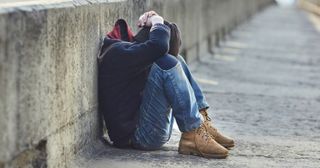 a young adult sits alone