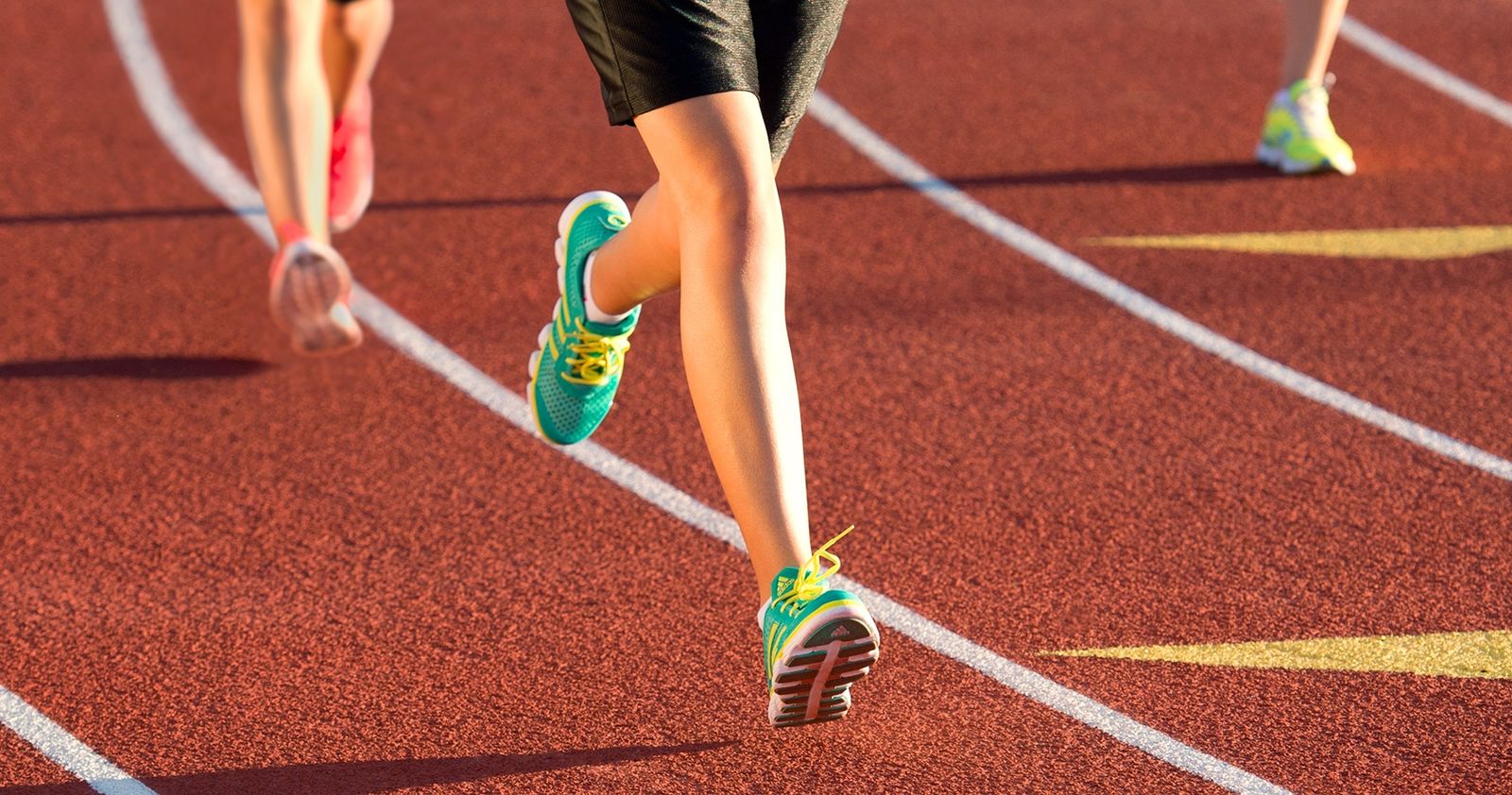 The legs of runners on a track.