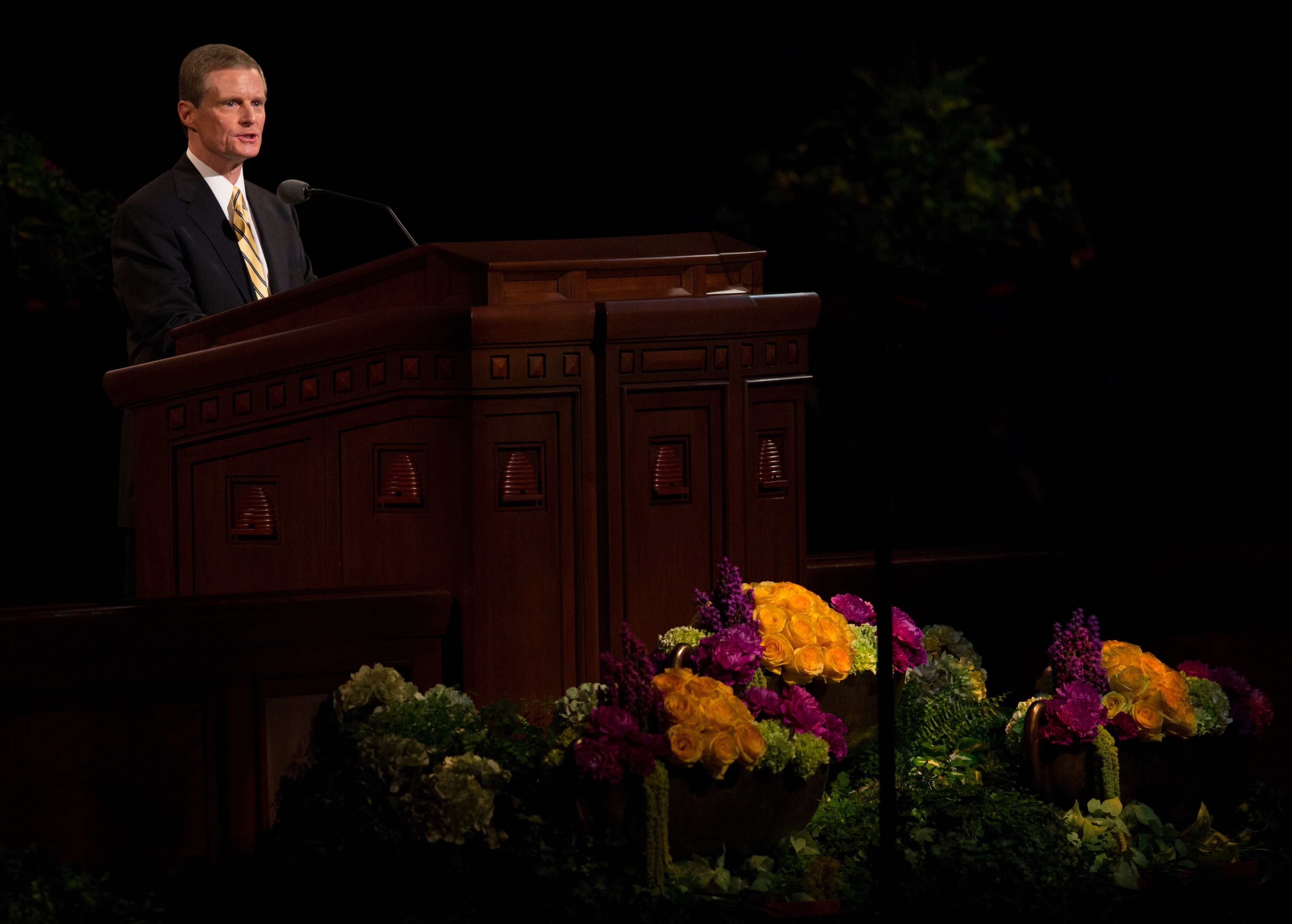 David A. Bednar standing at the pulpit and speaking at general conference.