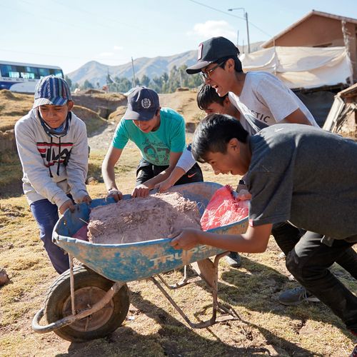 young men pushing wheelbarrow