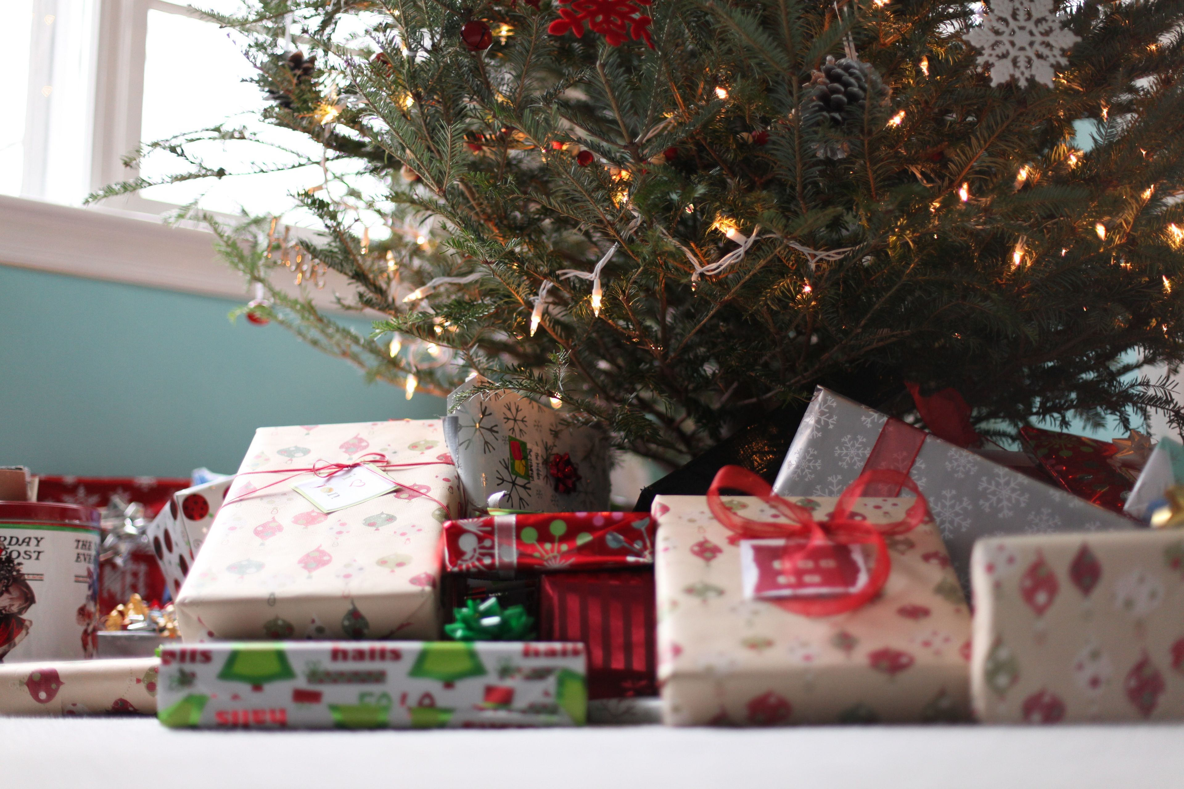 Wrapped gifts under a fresh Christmas tree.
