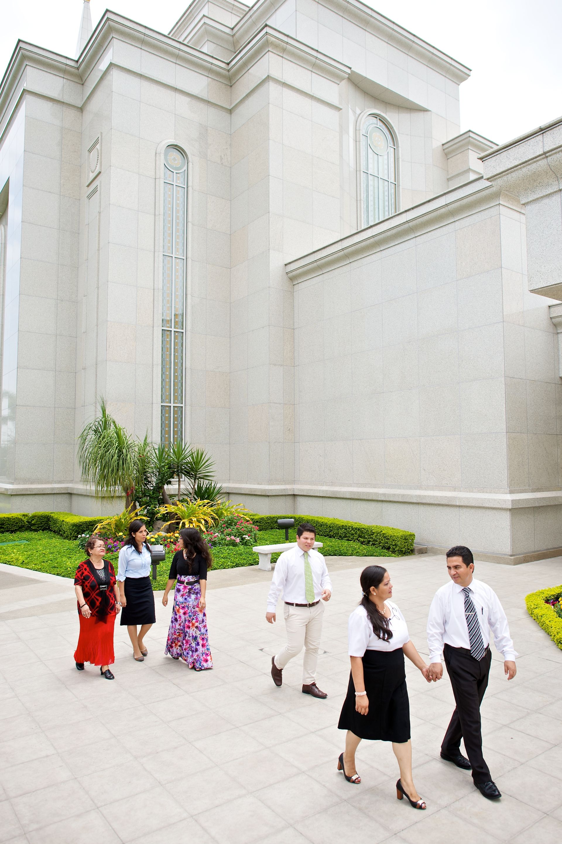 A couple walking with other adults outside the Guayaquil Ecuador Temple.
