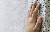 hand on granite wall