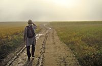 man walking down a dirt road