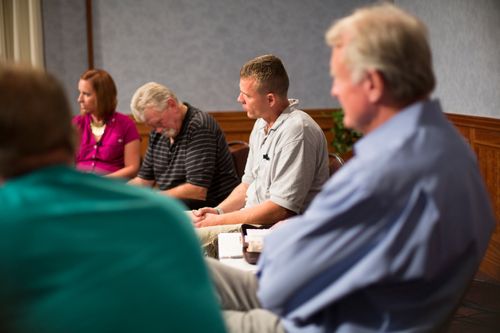 Men and women meeting together in an addiction recovery program.