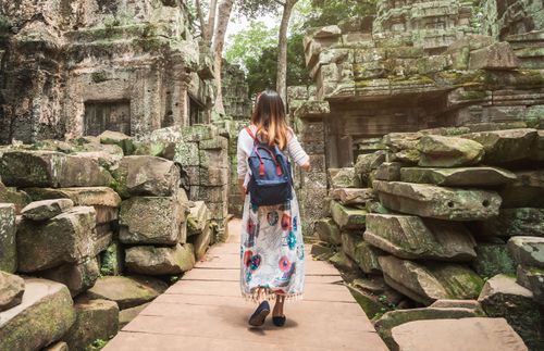 a woman walking among ruins