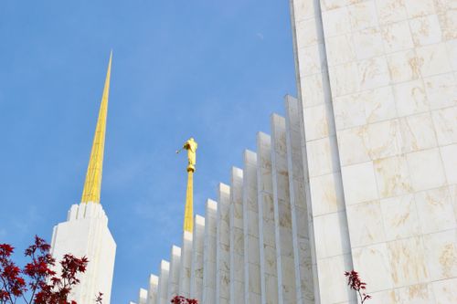 Two spires of the Washington D.C. Temple, with a partial view of the side and the angel Moroni on top.