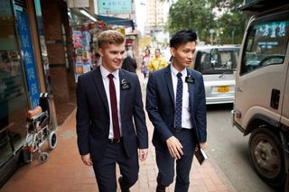 A series of images of two Elders in Hong Kong, China. They are out walking around the city contacting and talking to people they meet.