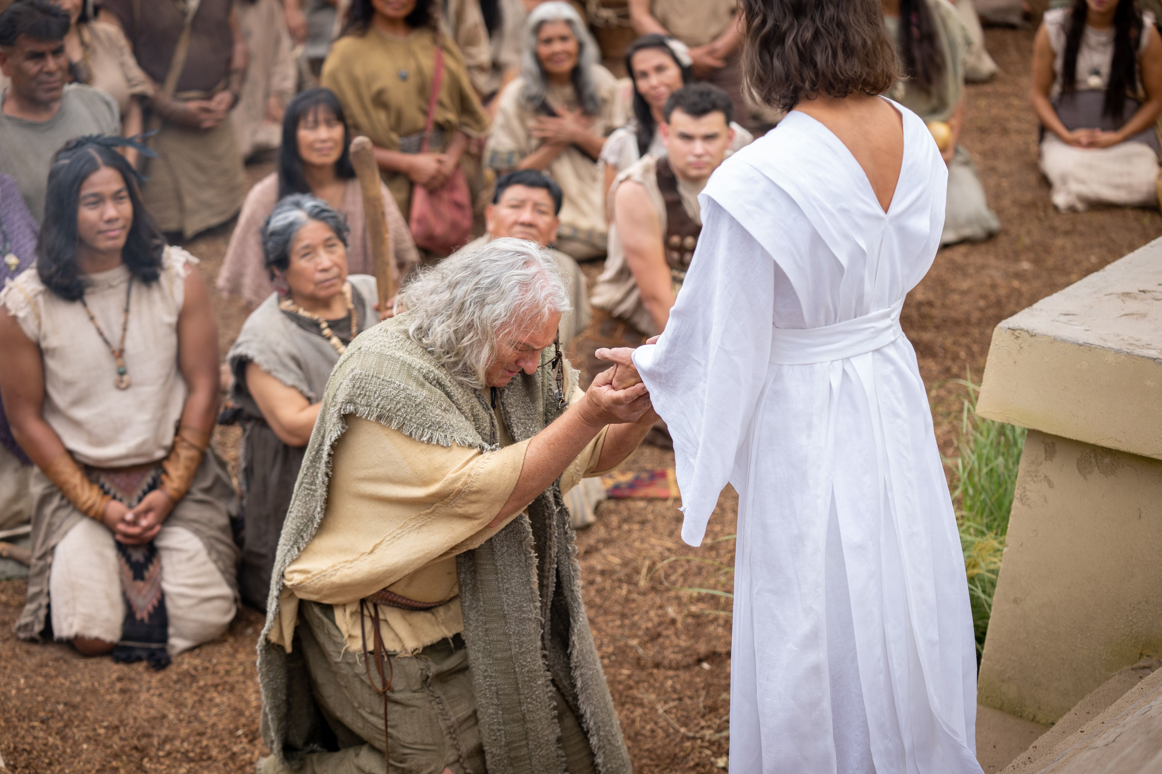 Jesus Christ comes to the Nephites. Nephi, son of Nephi, kneels before the Savior.