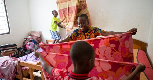 children folding up piece of cloth