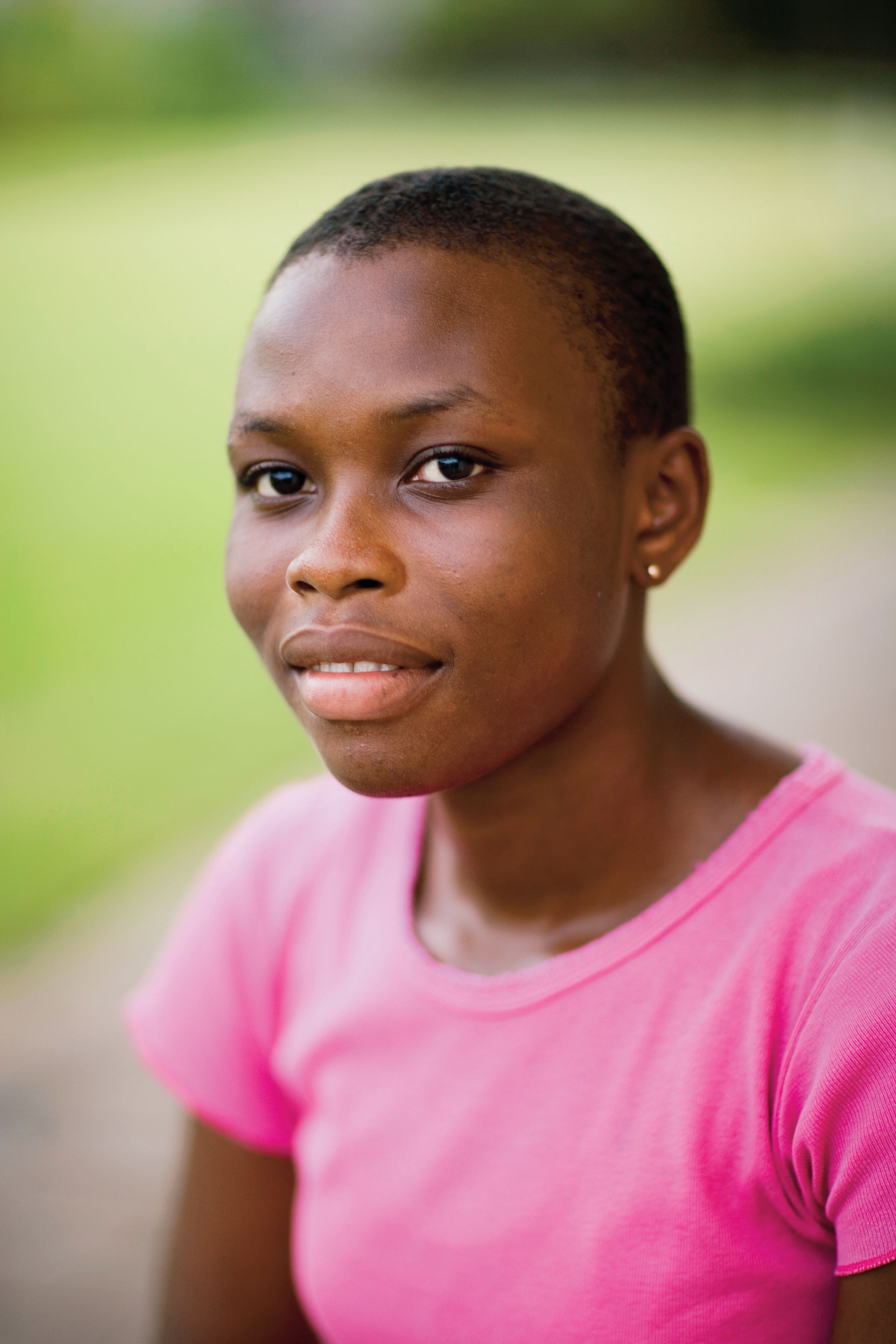 A portrait of a young woman in Ghana smiling.
