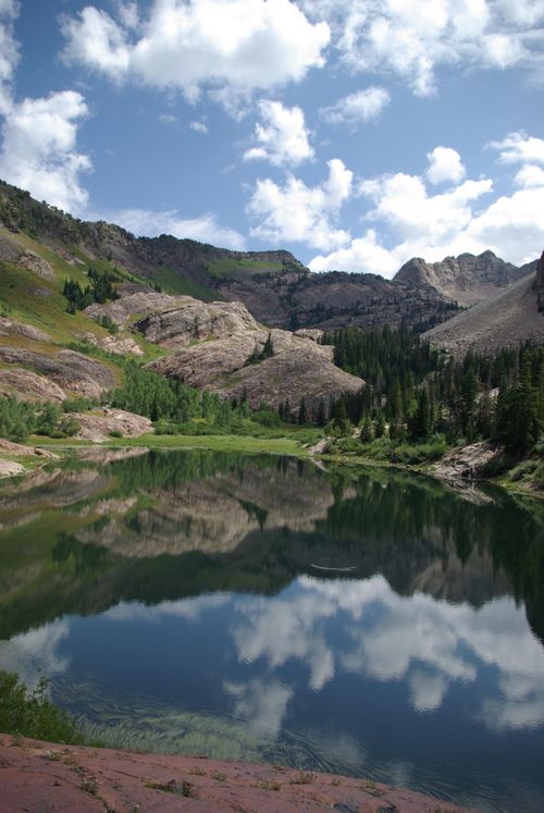A landscape image of a mountain and trees reflected in a lake.
