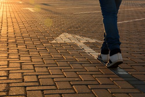 person walking on an arrow on a road