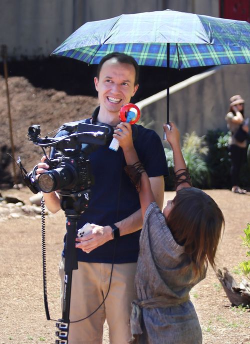 girl holding up umbrella for cameraman