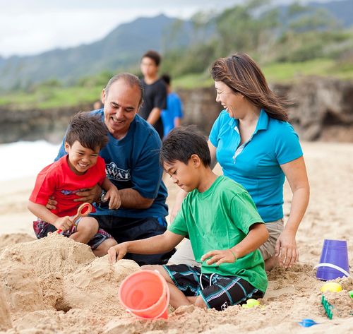 una familia construyendo un castillo de arena