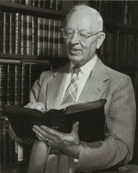 Joseph Fielding Smith holding open scriptures.