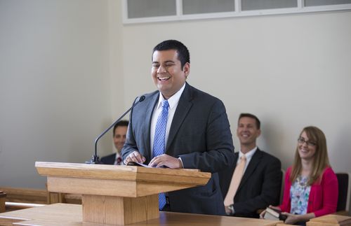 smiling man standing at pulpit