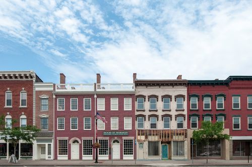 A row of red-, white-, and brown-brick buildings in Palmyra, New York, one of which is the Grandin Press Building.