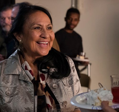 a woman smiling and holding food