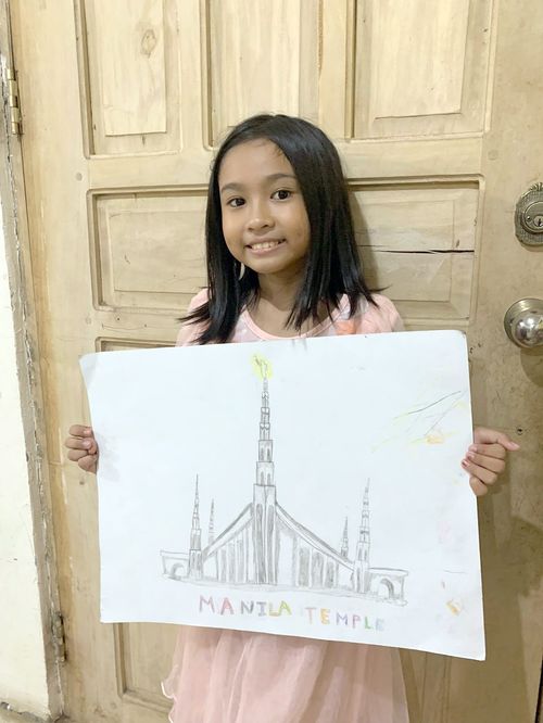 Photo of a girl named Unique Kesha Mae Sacay Salazar holding a drawing of the Manila Temple.