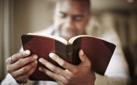 Un hombre estudia la Biblia en su casa y aprende cómo Jesús nos entiende.