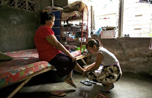 helping a woman put shoes on 