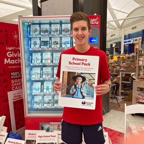 young man at Light the World giving machine